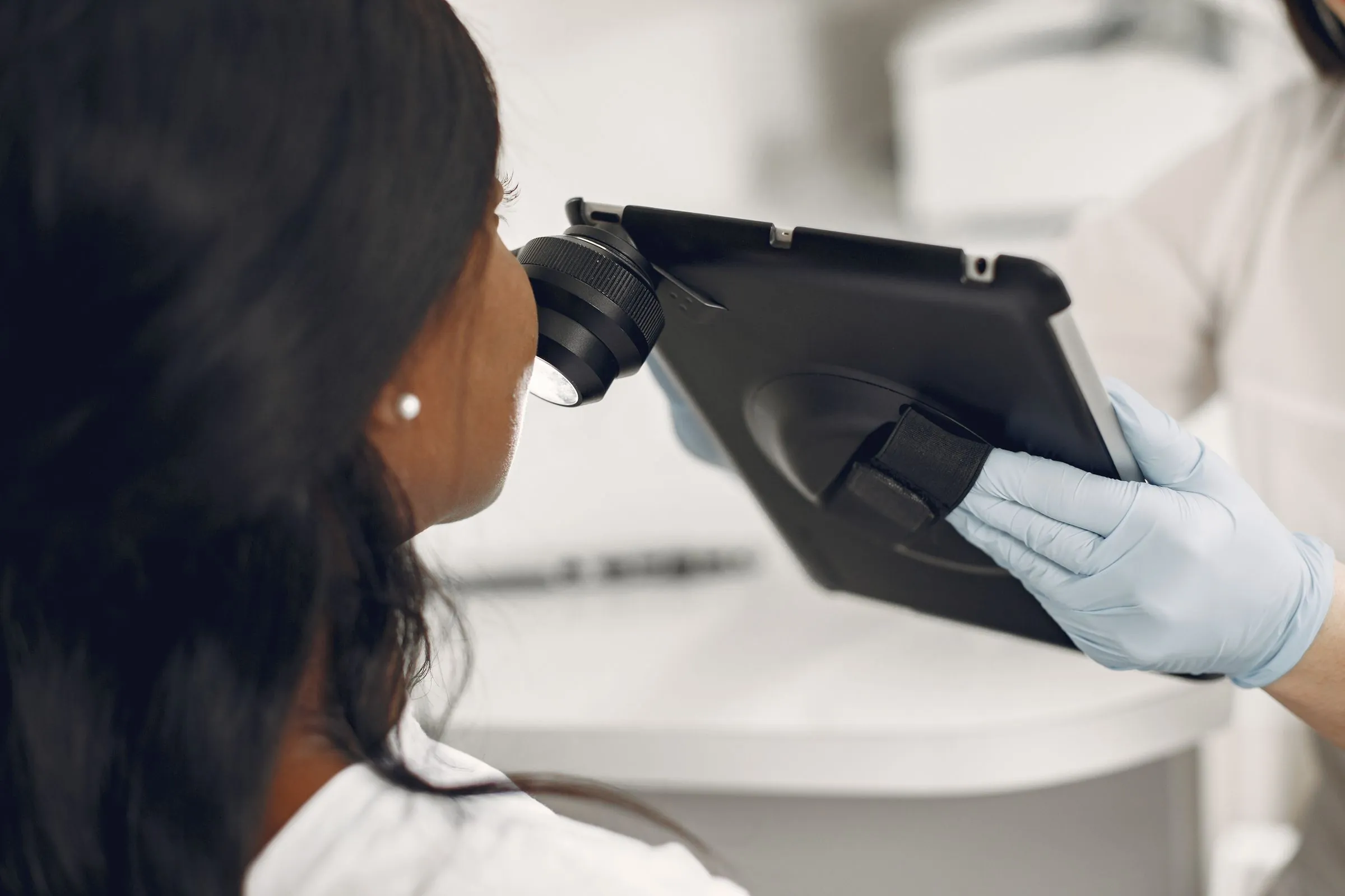 A dermatologist reviewing magnified skin images on a clinic monitor